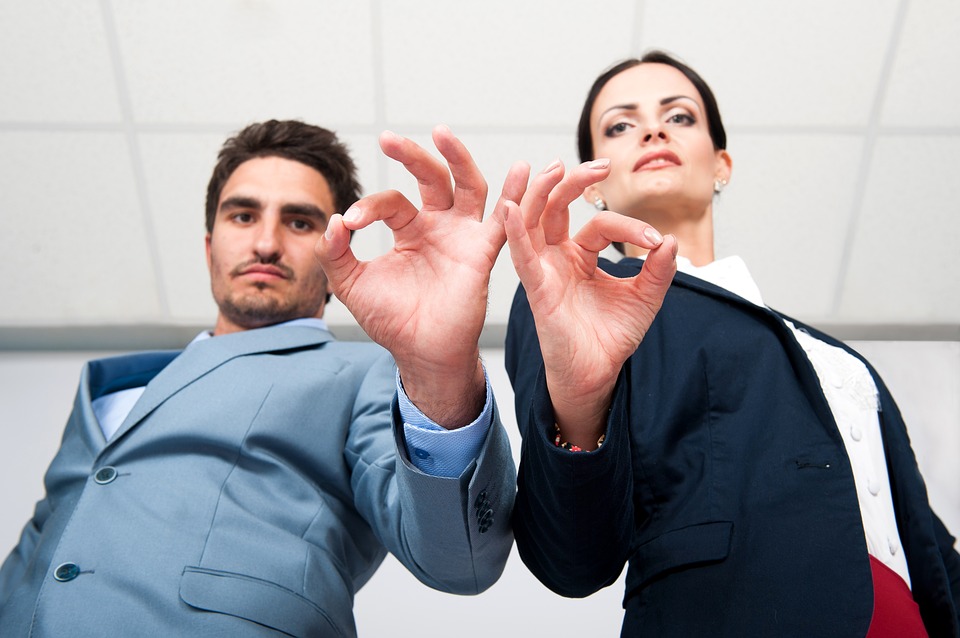 Man and woman on suit doing the OK sign to indicate a high-quality decision-making process